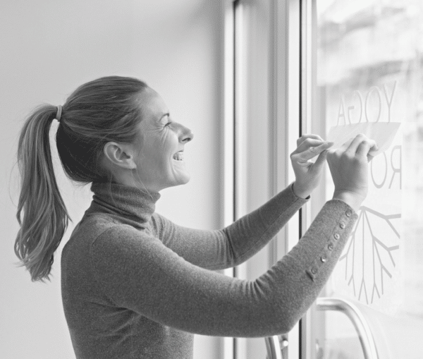 Woman applying decal to window