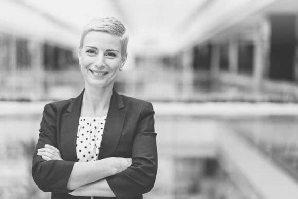 Lachende Frau steht im Bürogebäude